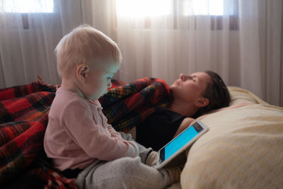 Side view of mother and daughter at home