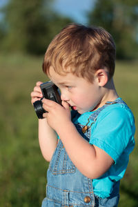 Close-up of boy photographing outdoors
