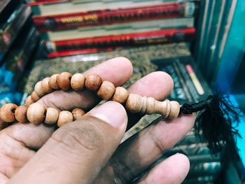 Close-up of hand holding prayer beads