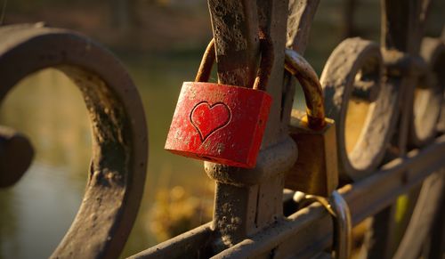 Close-up of padlocks hanging on rusty metallic gate