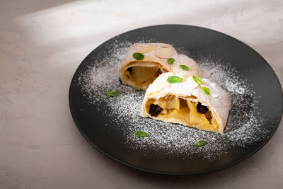 Close up of apple austrian strudel with cinnamon and mint on a plate