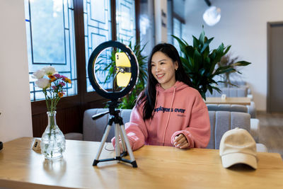 Smiling blogger vlogging at cafe