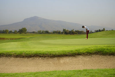 Full length of person on golf course against sky