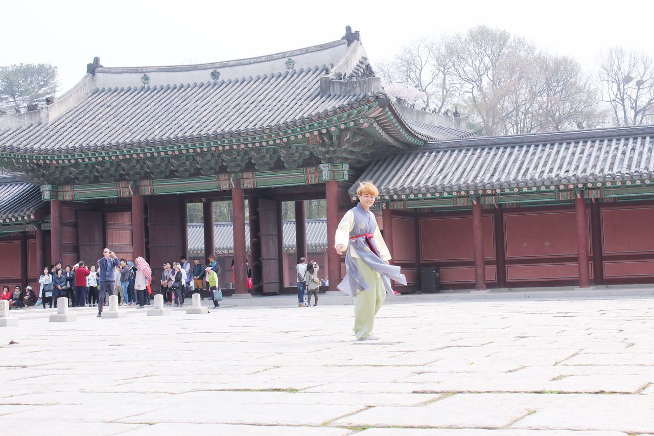 built structure, architecture, building exterior, lifestyles, leisure activity, full length, person, casual clothing, religion, place of worship, roof, tree, tradition, sky, temple - building, day, spirituality, men, outdoors