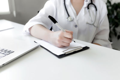 Midsection of man using mobile phone on table