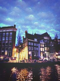 Buildings in city against cloudy sky