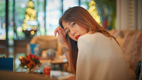 Portrait of young woman sitting at home