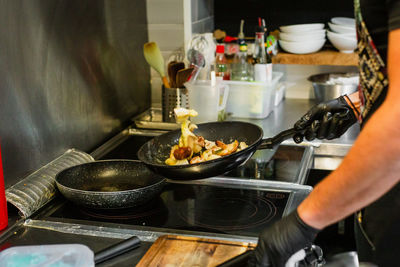 Midsection of man preparing food in kitchen