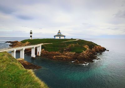 Lighthouse in sea against sky