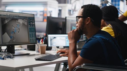 Side view of young man using laptop at table