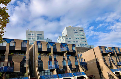 Low angle view of buildings against cloudy sky