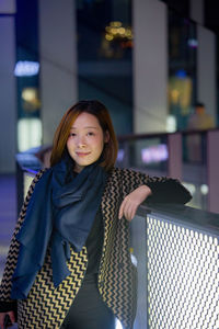 Portrait of smiling woman standing in balcony 