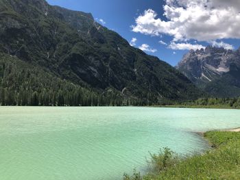 Scenic view of lake by mountains against sky