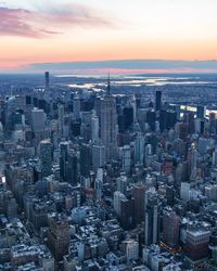 Aerial view of modern buildings against sky during sunset