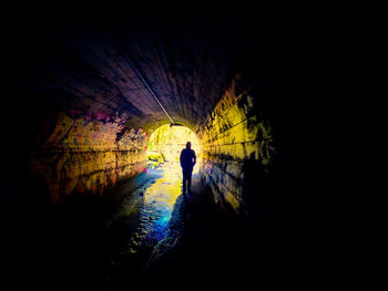 Silhouette of person in tunnel