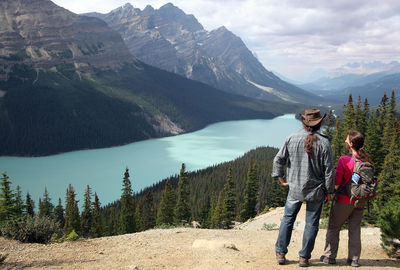 Rear view of hikers standing on mountain at banff national park