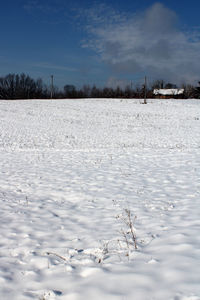 Scenic view of snow covered field against sky