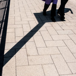 Low section of man standing on tiled floor