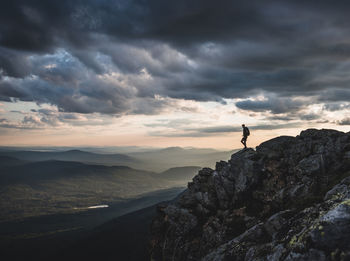 Lone hiker on mountain summit appalachian trail at sunset, maine.