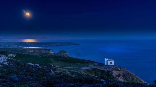 Scenic view of sea against blue sky at night