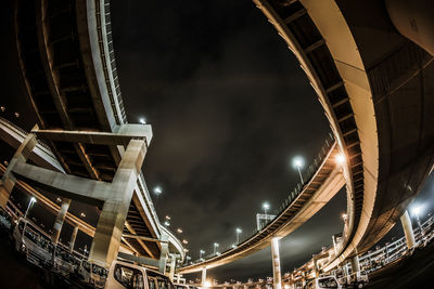 Low angle view of illuminated bridge at night