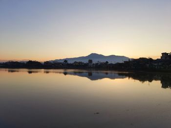 Scenic view of lake against clear sky during sunset