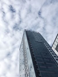 Low angle view of modern building against cloudy sky