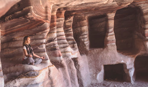 Woman meditating in cave