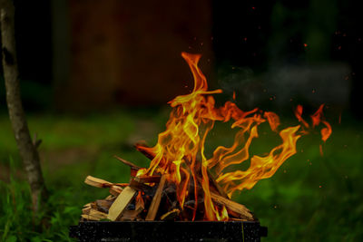 Close-up of bonfire on barbecue at night