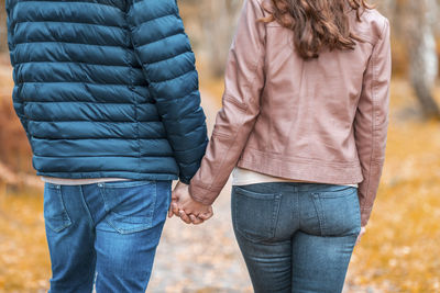 Midsection of couple standing in sunlight