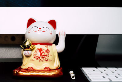 Close-up of maneki neko on table