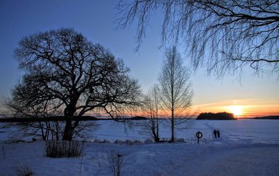 Scenic view of snow covered field at sunset