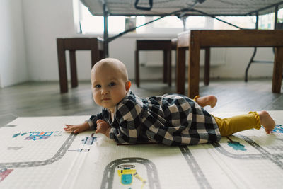 Cute baby girl playing with a toy on a play mat.