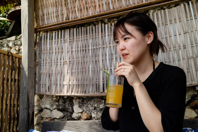 Portrait of a young woman drinking glass