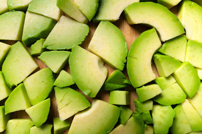 Close-up of fresh tasty finely chopped peeled avocado on a wooden cutting board. vegetarianism