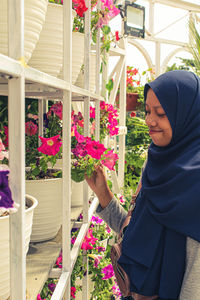 Woman standing by flowering plants