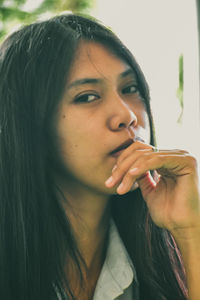 Close-up portrait of young woman drinking water