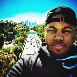 Portrait of man against car against sky