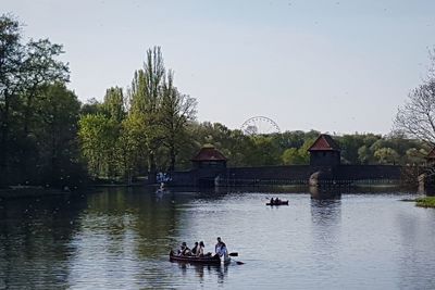 People in lake against sky