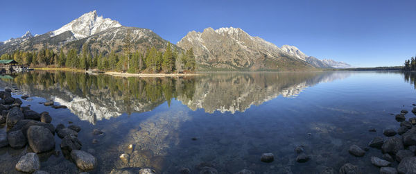 Scenic view of lake and mountains against blue sky