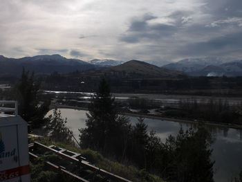 Scenic view of river against cloudy sky