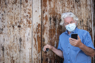 Midsection of man using mobile phone outdoors