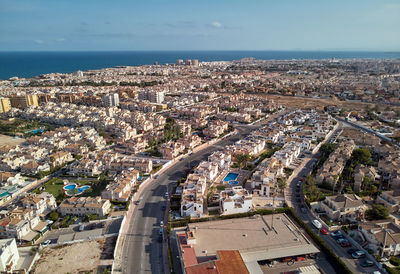 High angle view of city by sea against sky