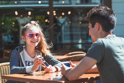 Portrait of smiling woman sitting on table at cafe