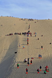 High angle view of people on sand against sky