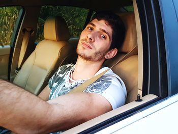 Portrait of young man sitting in car