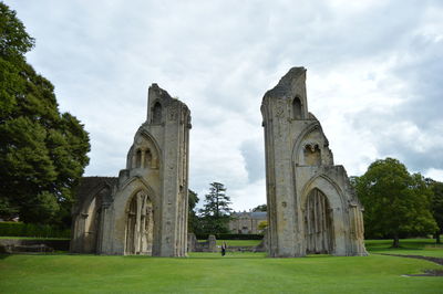 Low angle view of glastonbury abbey against cloudy sky