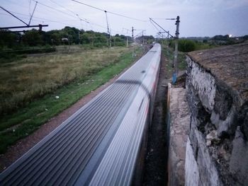 Railroad tracks on field against sky