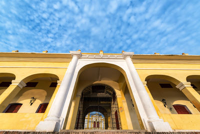 Low angle view of yellow building against sky