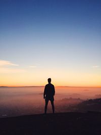 Silhouette of man overlooking calm sea